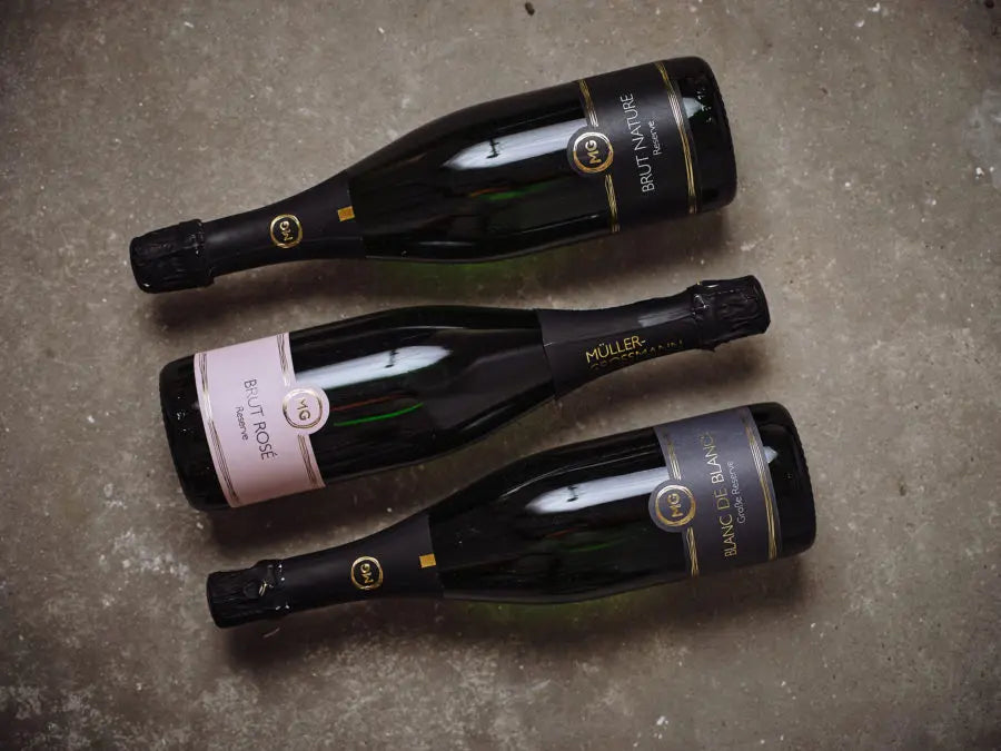 Drie flessen mousserende wijnen van Weingut Müller Grossmann, geproduceerd volgens de traditionele champagnemethode.